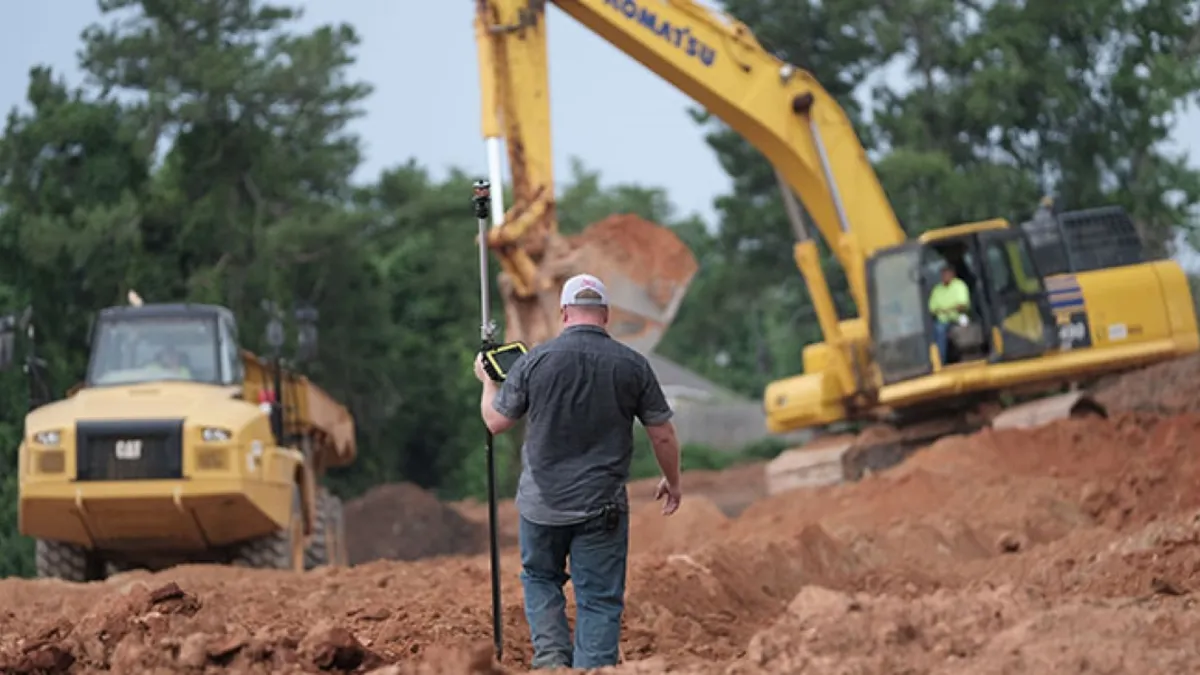 A man with a white cap enters a construction zone.