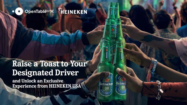 A group of people clink bottles of Heineken 0.0.