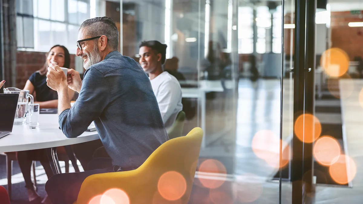 Cheerful businessman attending a meeting with his team stock photo