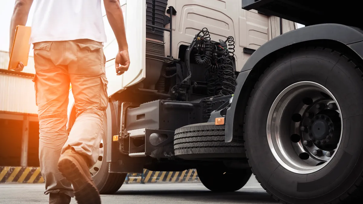 A truck driver walking around semi truck his inspecting and safety check to before driving semi truck.