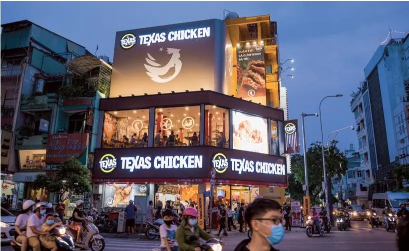 An evening image of a buildign with white letters that says Texas Chicken