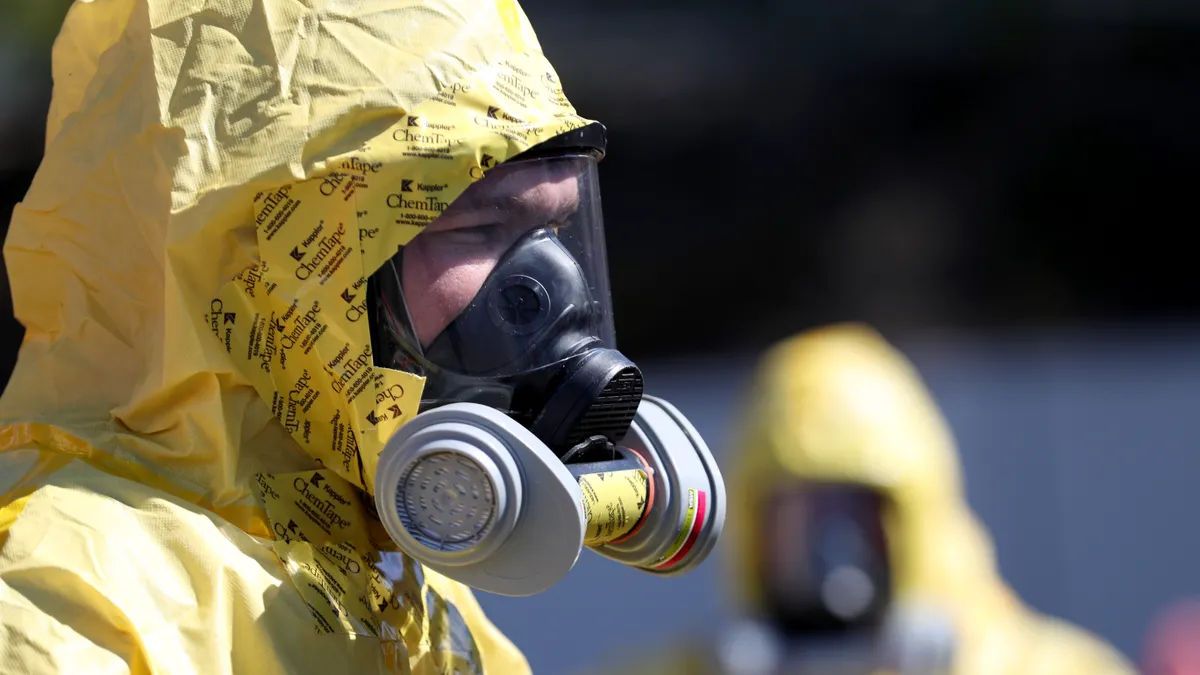 Clean Harbors worker in yellow hazmat suit and oxygen mask