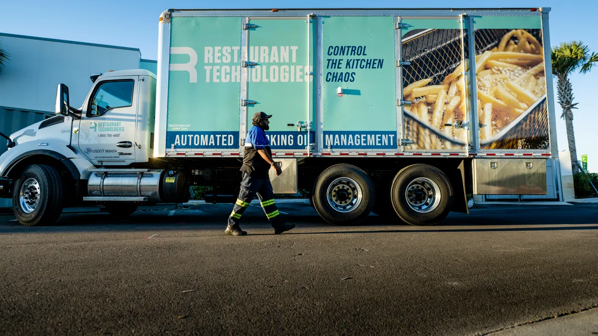 Restaurant Technologies truck with a trucker walking by it