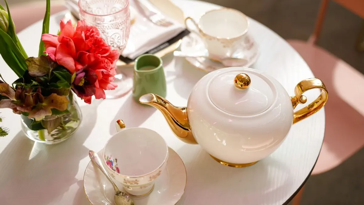 A table with a teapot and tea during high tea service.