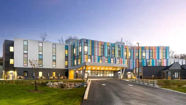 A photograph shows a colorful, newly built psychiatric hospital.