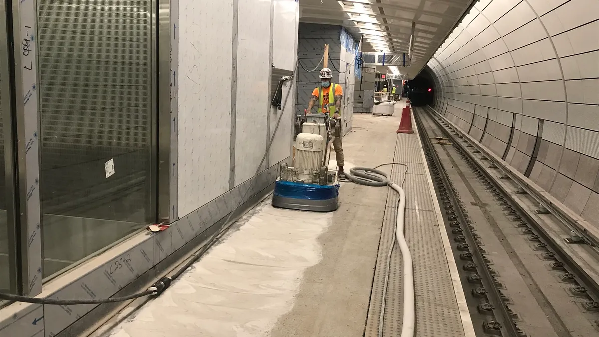 Sanding the installed terrazzo flooring in the future LIRR passenger terminal.