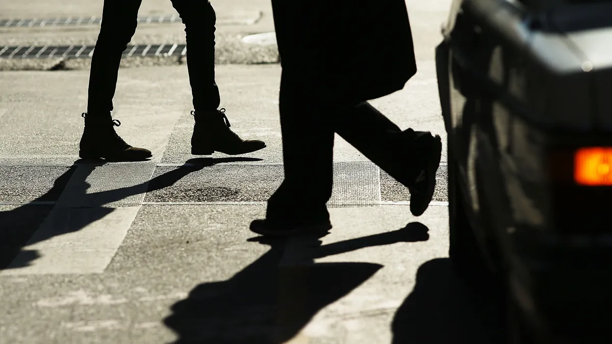 Overhead view of pedestrians crossing a street in midtown Manhattan.