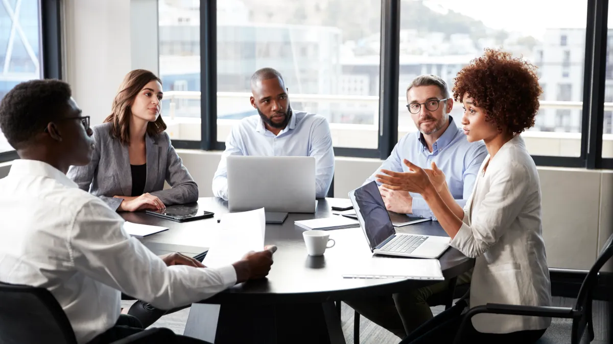 Millennial black businesswoman addressing colleagues at a corporate business meeting, close up