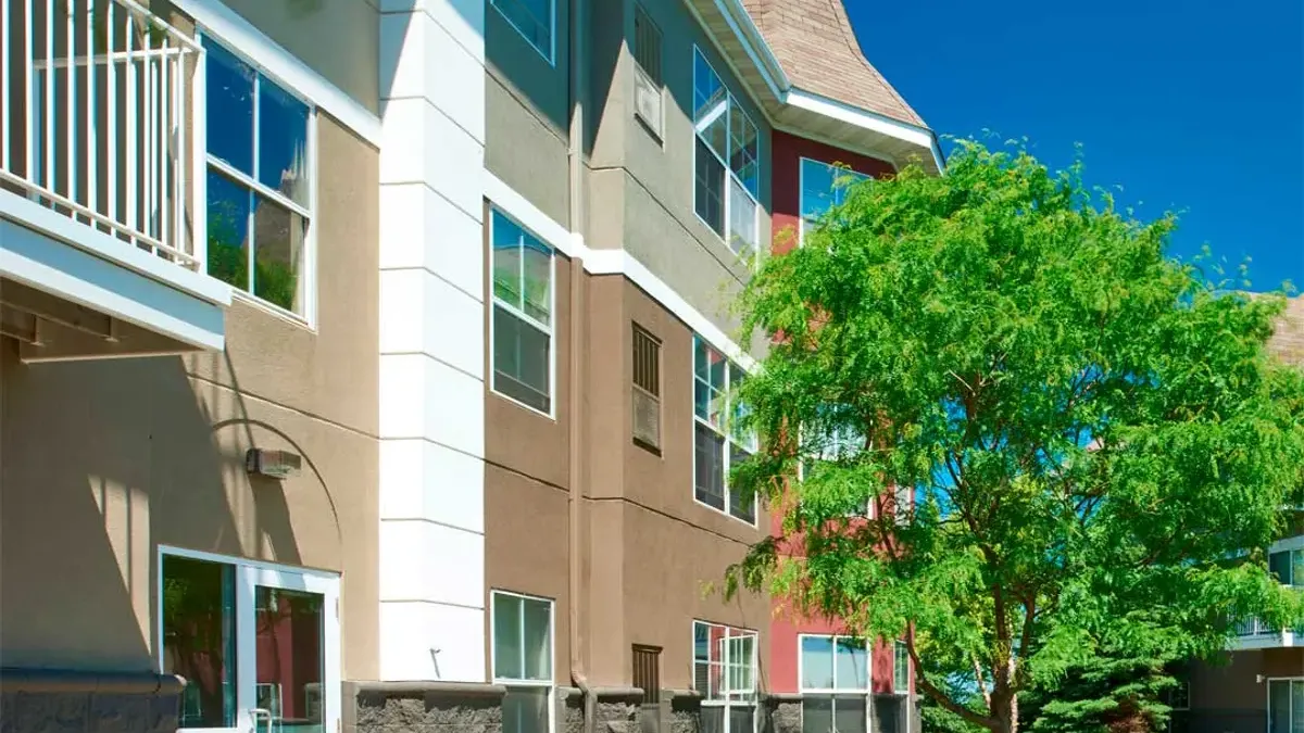 Apartment property with trees and grass to the right