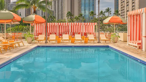 A pool surrounded by colorful deck chairs.