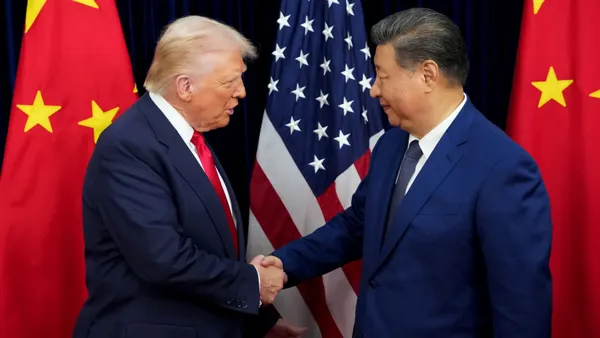 U.S. President Donald Trump (left) shakes hands with China President Xi Jinping in front of flags of their respective countries.