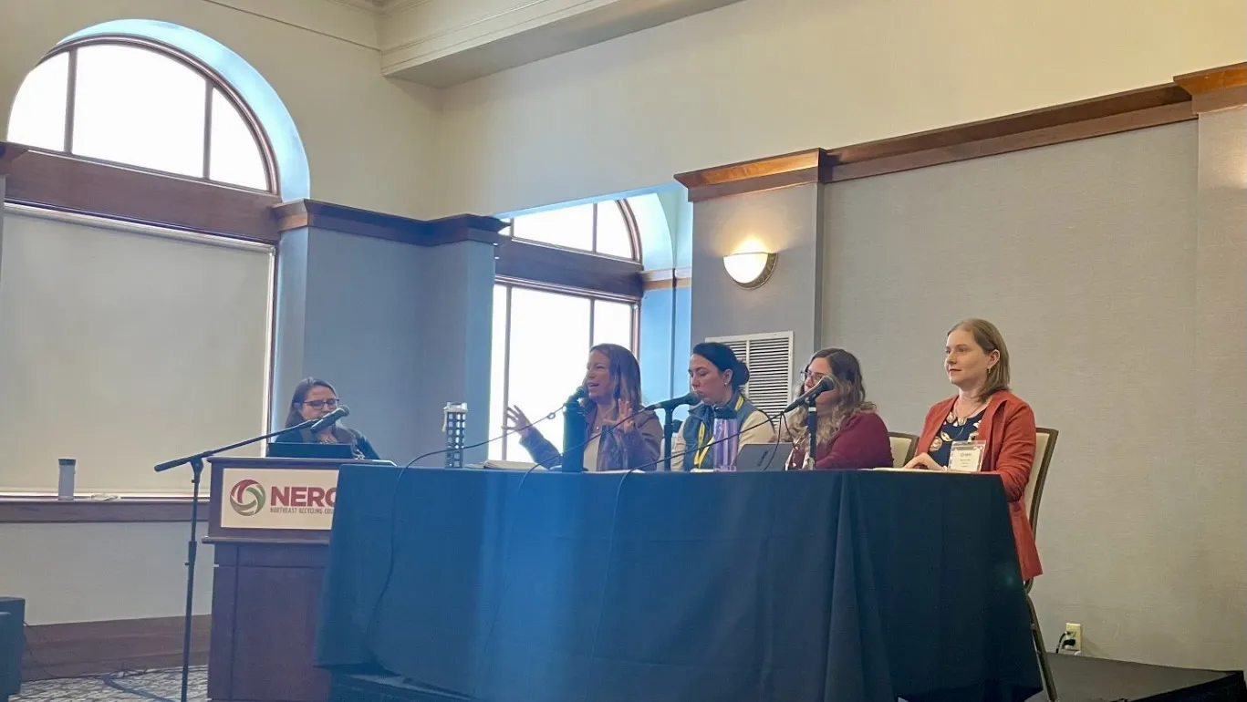 One moderator and four seated panelists discuss extended producer responsibility at an event in Providence