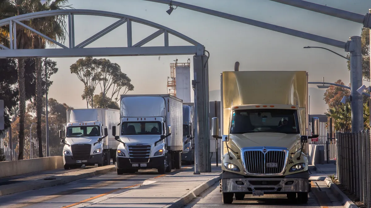 Trucks drive across the U.S.-Mexico border on Feb. 1, 2025, in San Diego.