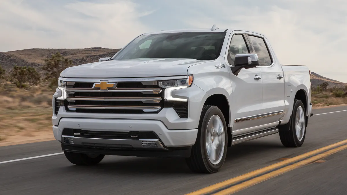 A white 2022 Chevy Silverado High Country edition driving on a road.