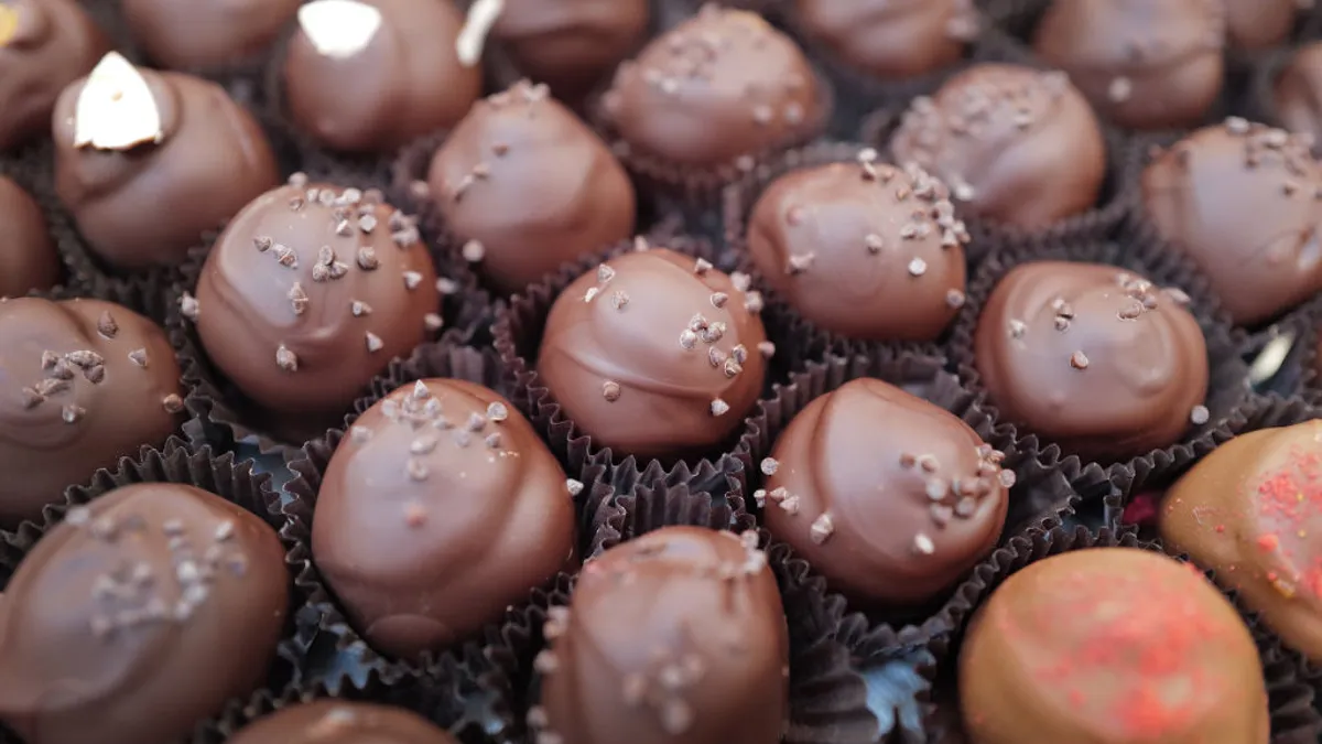 A display of chocolates held by parchment wrappers.