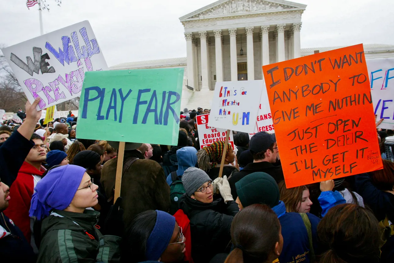 A crowd of protestors stand outside the U.S. Supreme Court holding picket signs