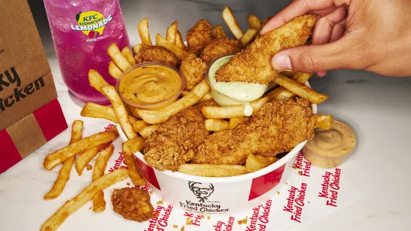 A bucket of chicken tenders, nuggets and french fries.