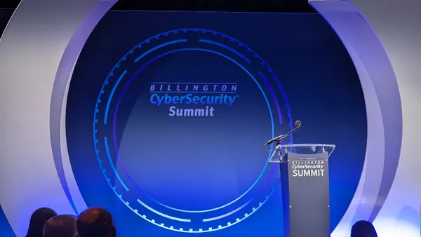 An empty stage and lectern sit in front of a backdrop that reads "Billington Cybersecurity Summit"