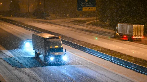 Passenger and commercial traffic with lights on move in the dark along a Florida highway affected by snowfall.