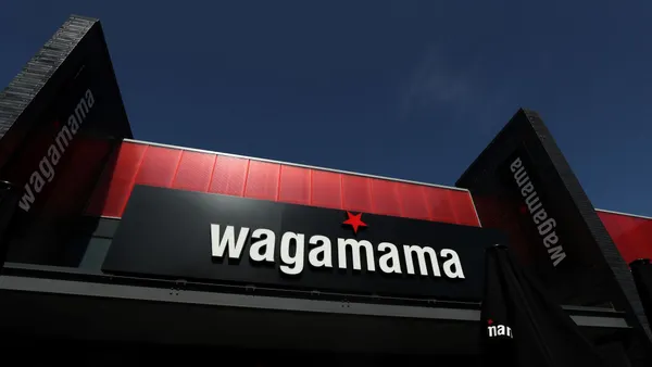 An iamge of a building with black facade and white logo that says "Wagamama."