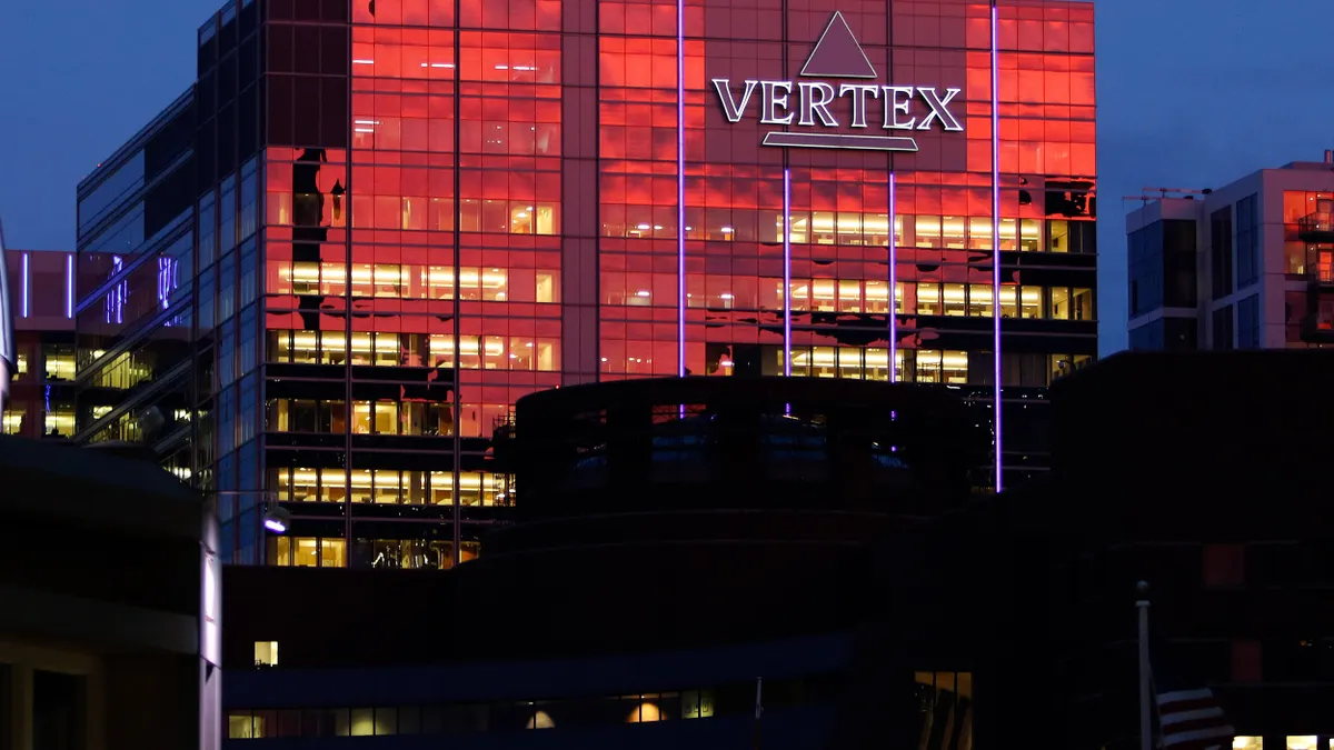 A building is seen at sunset with the word Vertex visible on its side.