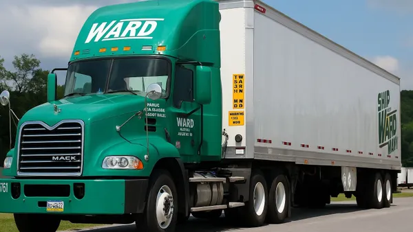 A green freight truck at rest.
