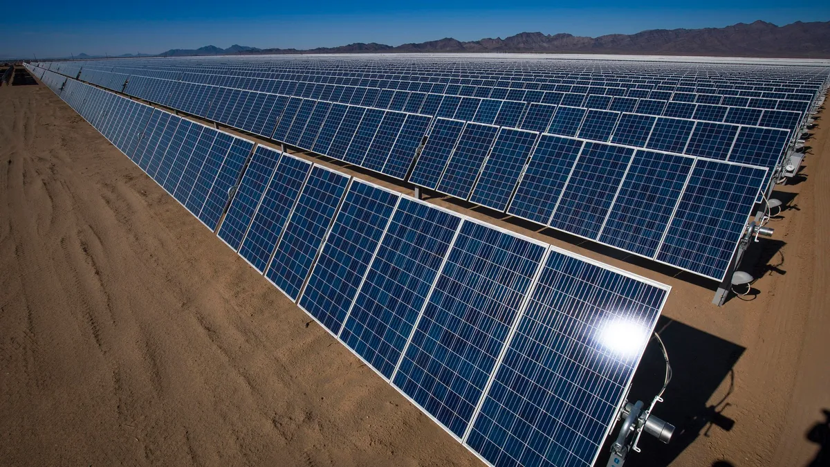 Rows of blue solar panels stretch into the desert horizon.