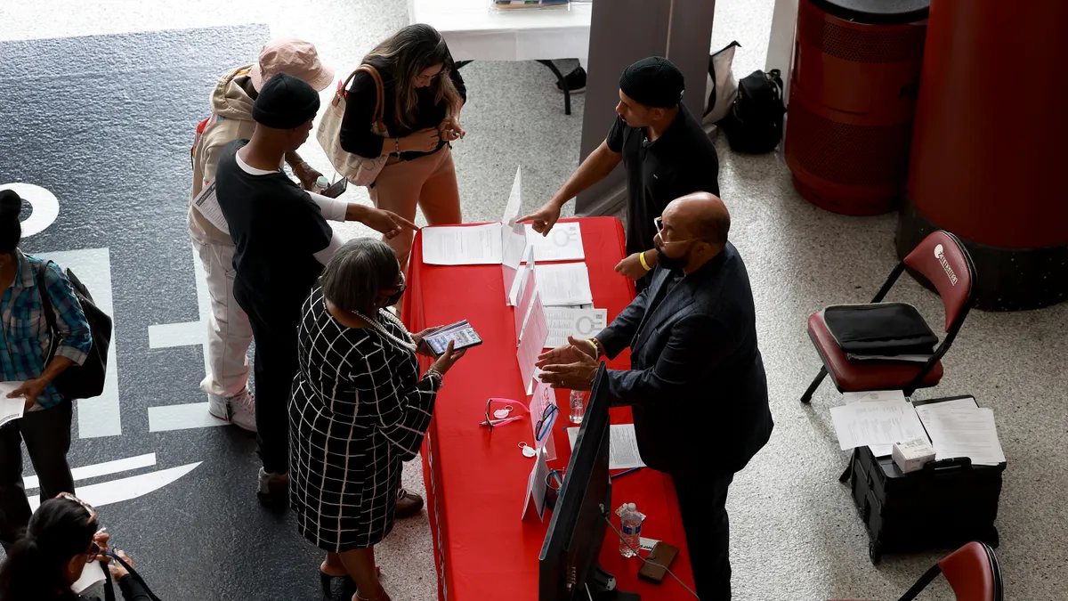 Job seekers meet with recruiters during a career and training fair.