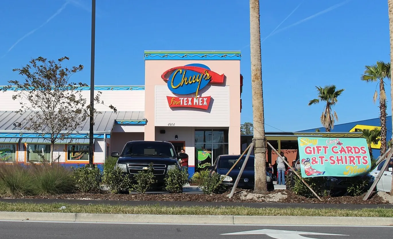 An image of a pink building with a Chuy&#x27;s sign on the side.