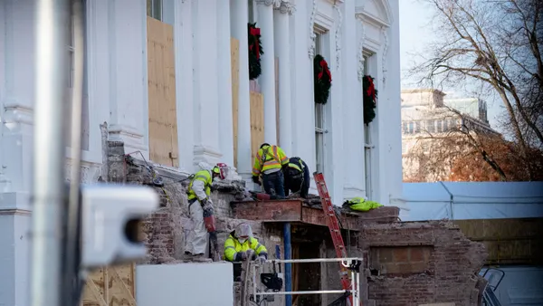 Workers continue to work where the East Wing used to connect to the White House