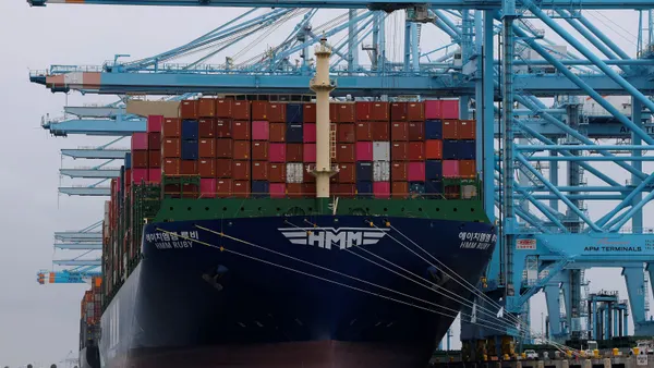 A container cargo ship docked at a shipping terminal.
