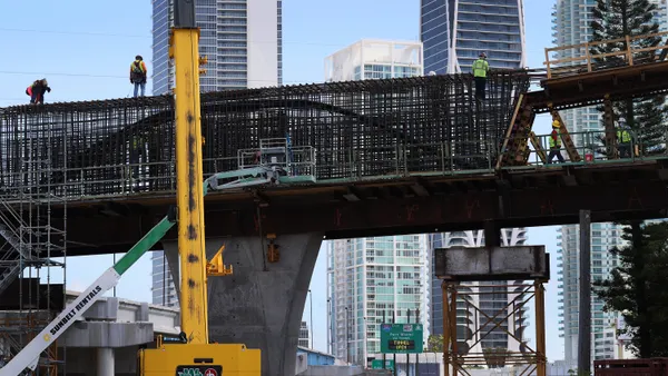 A team of construction workers builds a piece of a large bridge.