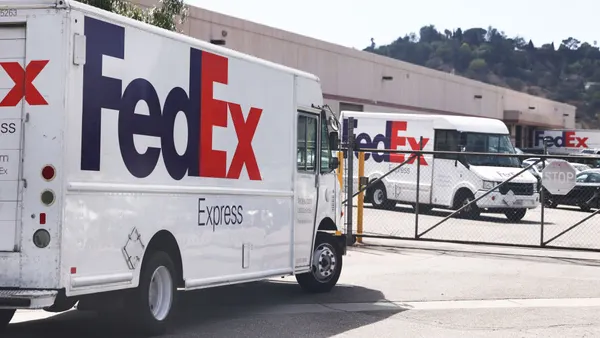 FedEx trucks are parked at a FedEx facility.