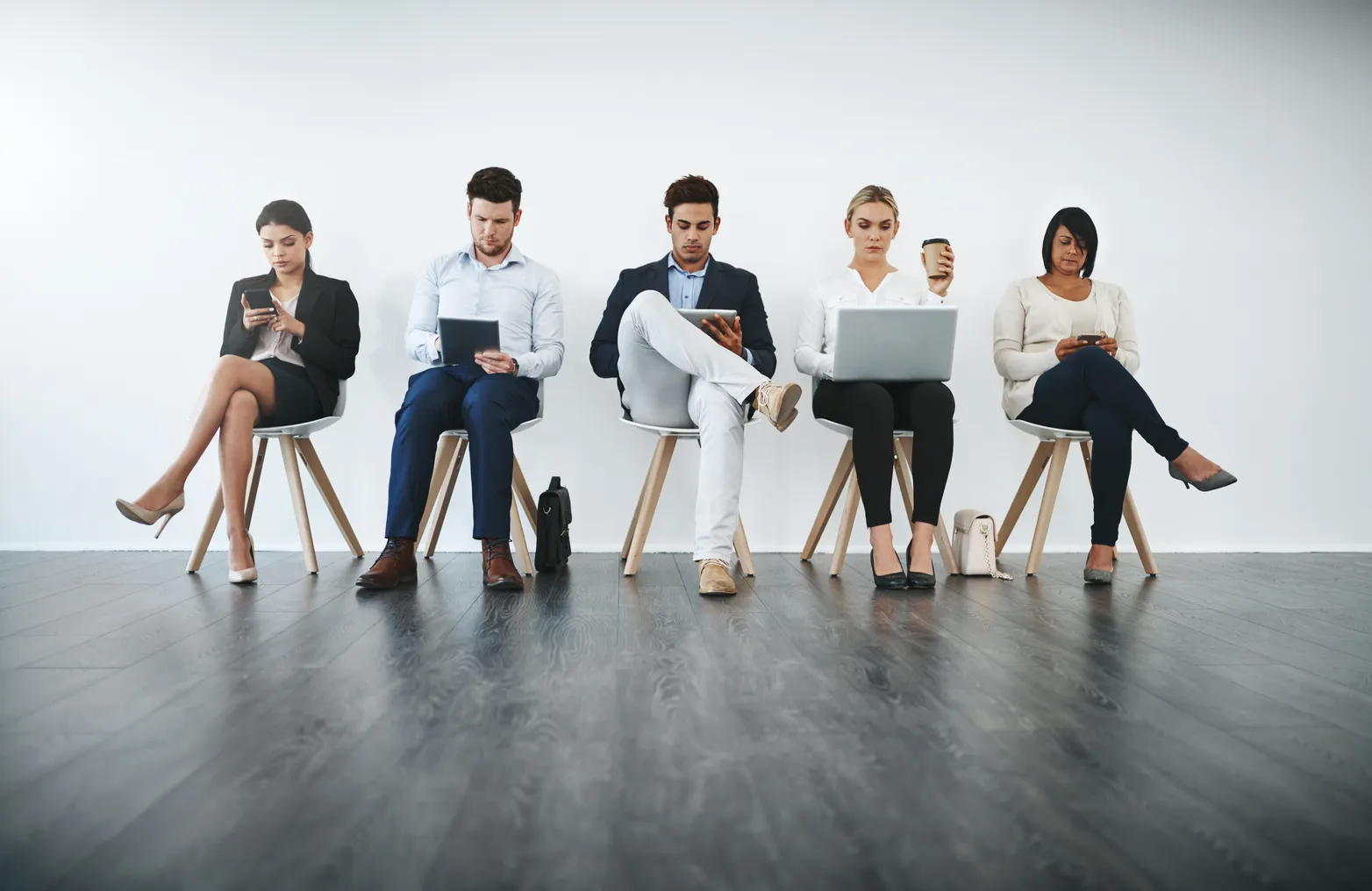 Full length shot of a group of businesspeople waiting in line for their interviews