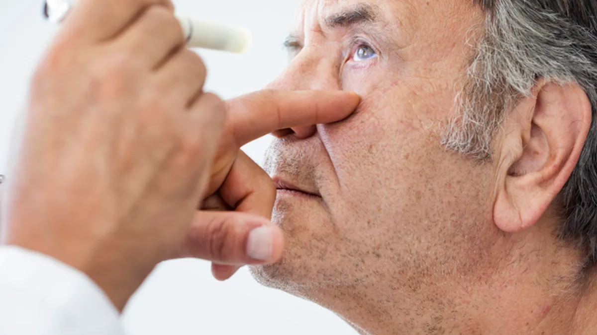 A doctor shines a light in a patient's eye.