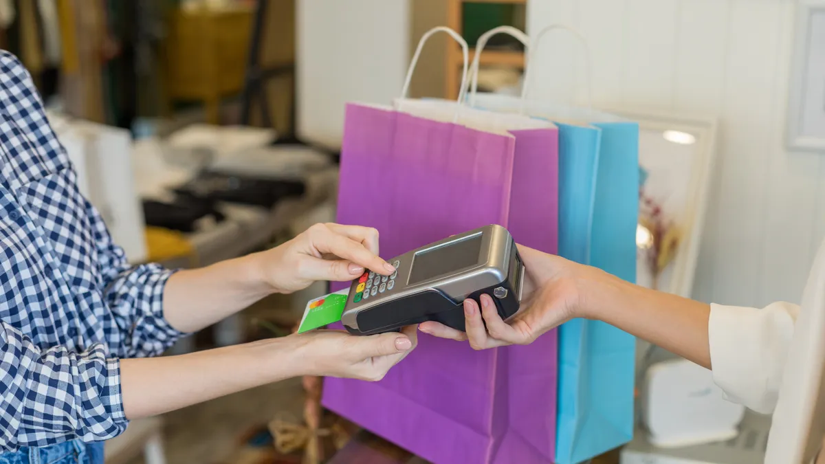 Woman paying at boutique.