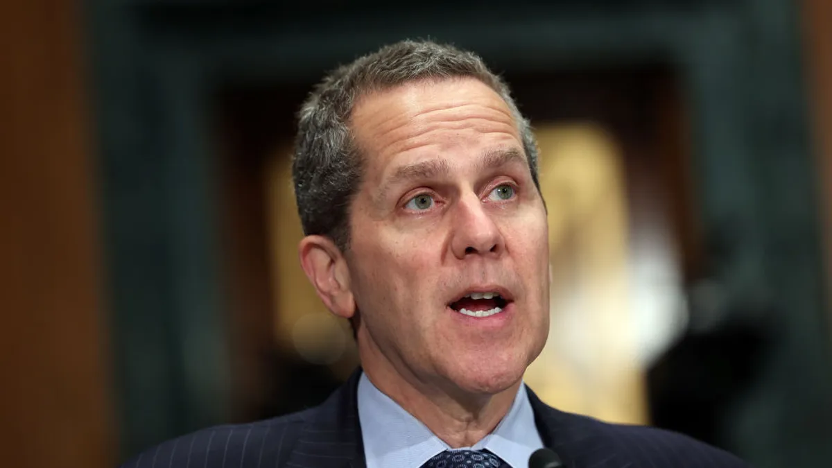 Federal Reserve Gov. Michael Barr speaks into a microphone during a congressional hearing.