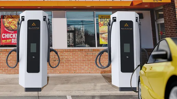 A photograph of white EV charging stations in a parking lot in front of a Bojangles restaurant.