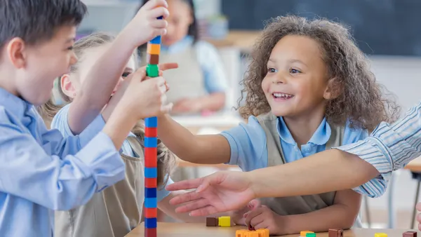 Young students work together on a cube tower in a classroom