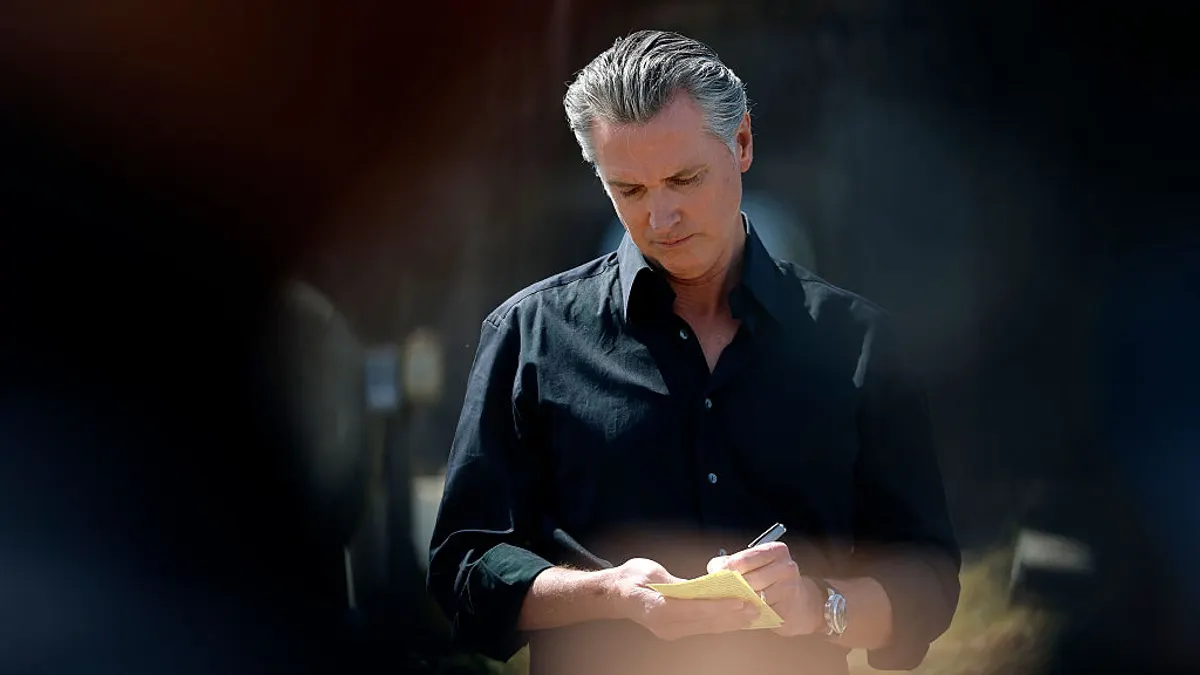 California Governor Gavin Newsom takes notes during a news conference at Gemperle Orchard on April 16, 2025 in Ceres, California.