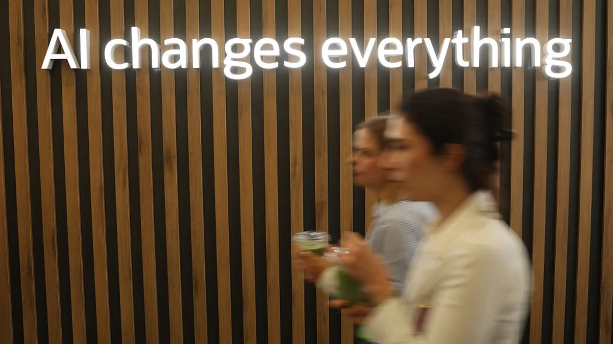 Sign above conference attendees reads "AI changes everything" referring to artificial intelligence