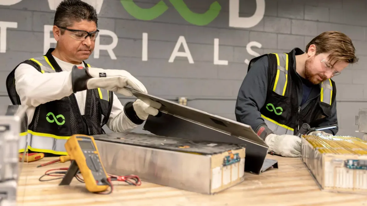 Workers at Redwood Materials inspect used batteries for recycling.