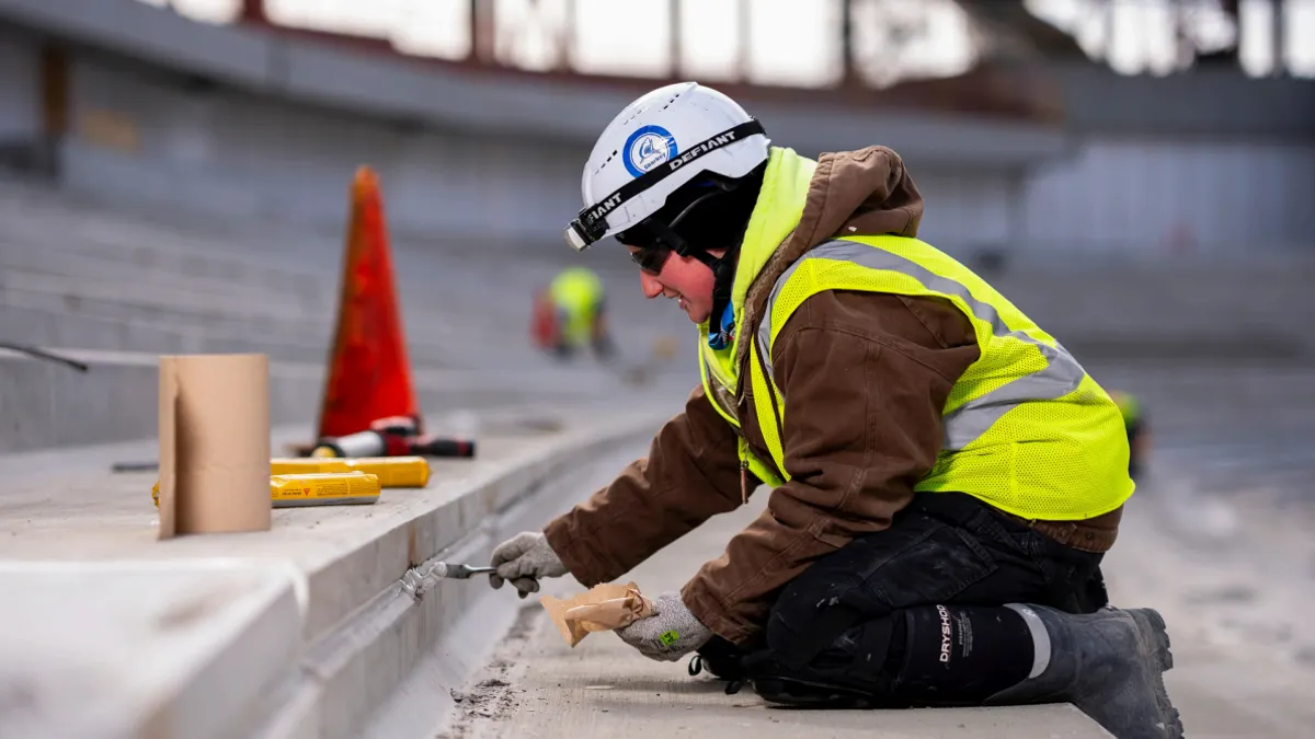 A construction worker kneeling on a jobsite.