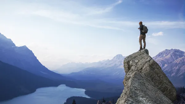 hiker on top of rock with view of mountains