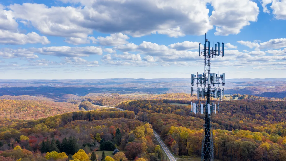 Aerial view of mobiel phone cell tower over forested rural area of West Virginia to illustrate lack of broadband internet service.