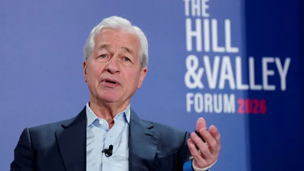 JPMorgan Chase CEO Jamie Dimon, wearing a suit, gestures while speaking in front of a blue background with the words "The Hill & Valley Forum 2026."