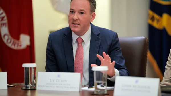 A person wearing a suit sits at a table.