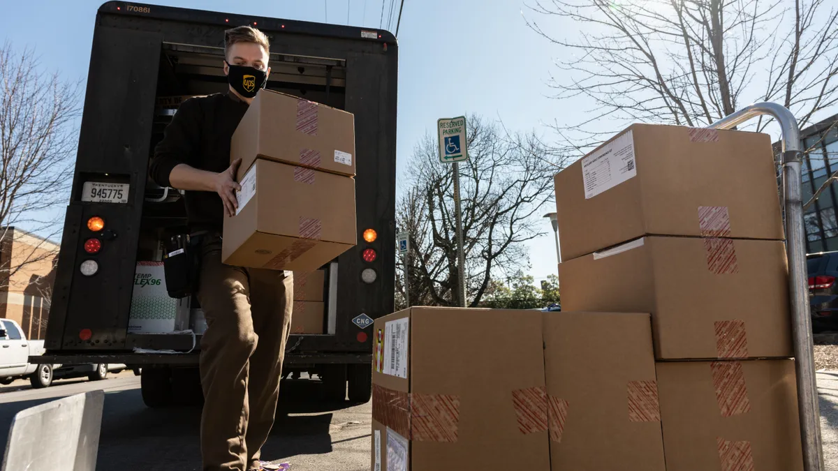 Adam Dentinger, a UPS delivery driver, unloads a shipment of Janssen COVID-19 vaccines and ancillary kits at Louisville Metro Health and Wellness headquarters on March 4, 2021 in Louisville, Kentucky