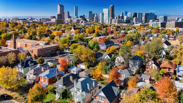 Aerial view of houses with a city skyline in the background.