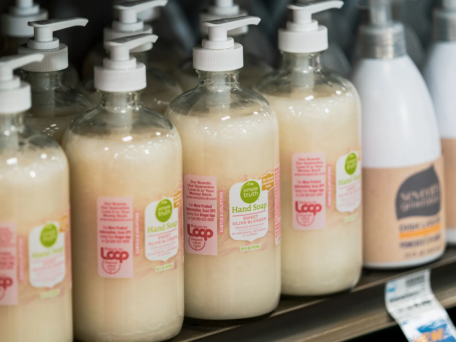 Close-up of bottles of hand soap on a shelf.